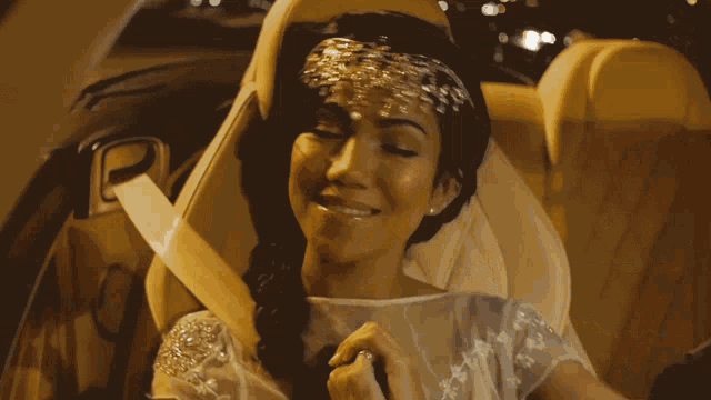 a woman in a white dress is sitting in the back of a car