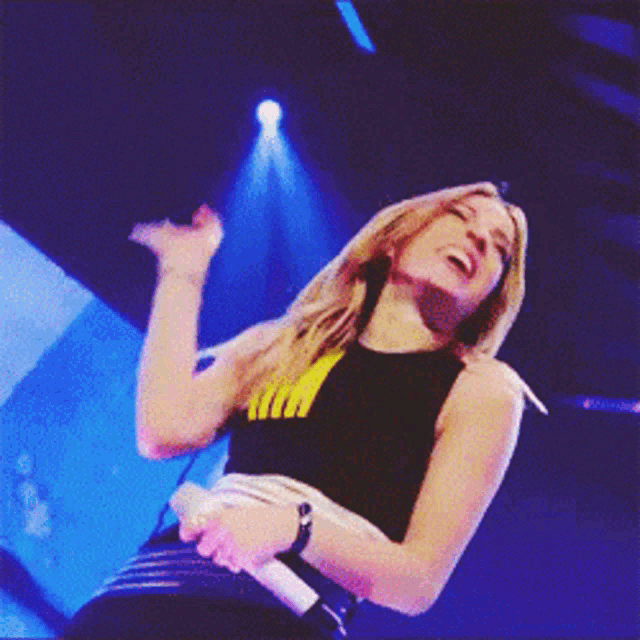 a woman singing into a microphone with a shirt that says ' i love you ' on it