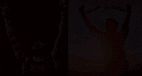 a man singing into a microphone next to a silhouette of a man holding chains in his hands