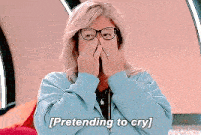 a woman wearing glasses is pretending to cry while making a face .