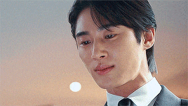 a close up of a man wearing a suit and tie