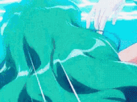 a person in a green shirt is swimming in a blue pool .