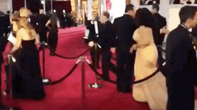 a group of people are standing on a red carpet at an awards ceremony .