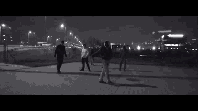 a black and white photo of a group of people walking down a street