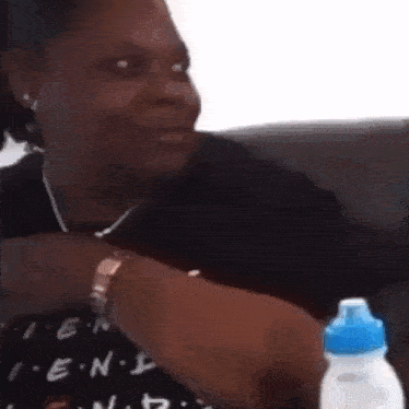 a woman is sitting on a couch with a bottle of water .