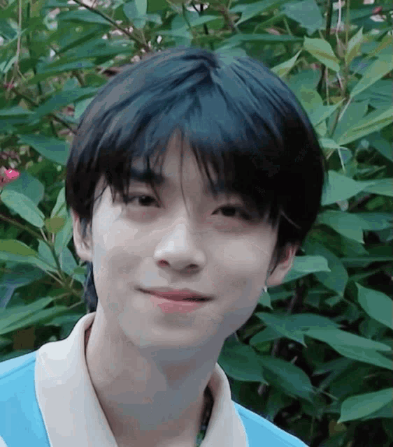 a close up of a young man 's face with a blue shirt on