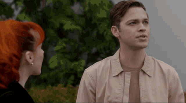 a man and a woman are standing next to each other and the woman has red hair