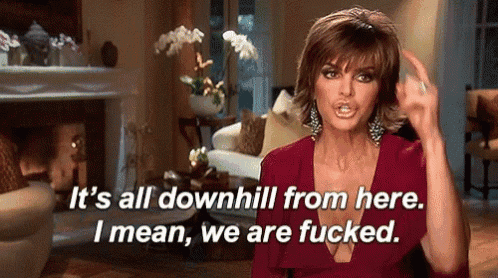 a woman is sitting in a living room with a fireplace and says `` it 's all downhill from here .