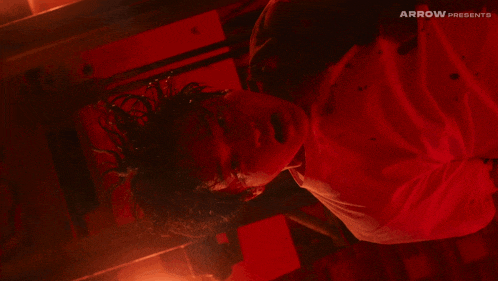 a man is laying on his back in a dark room with arrow presents written on the bottom of the image