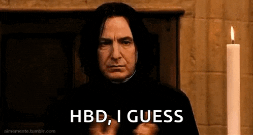 a man in a black robe is standing in front of a candle .
