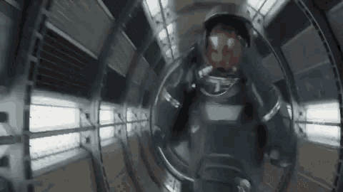 a man in an astronaut 's helmet is walking through a tunnel .