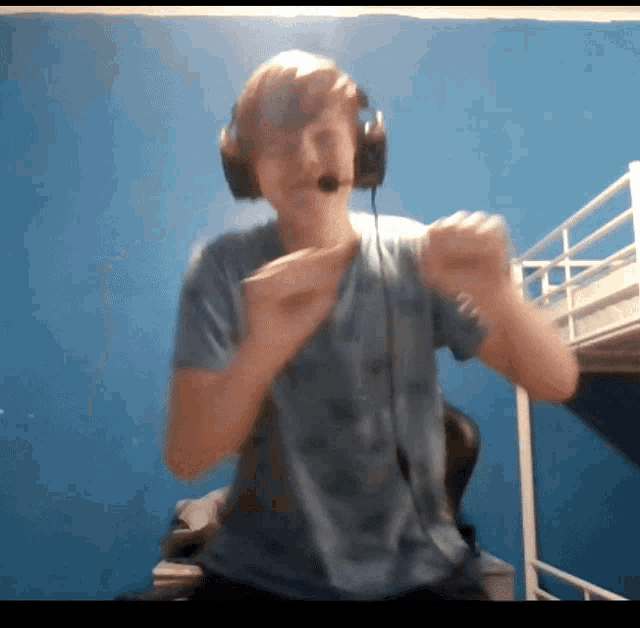 a young man wearing headphones and a microphone stands in front of a bunk bed