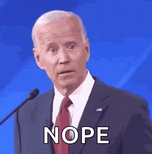a man in a suit and tie is standing in front of a microphone and says nope .