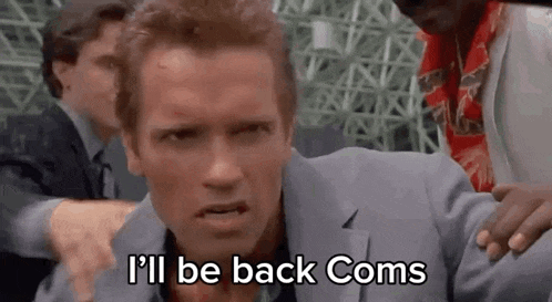 a man in a suit is standing next to a group of men and says `` i 'll be back coms ''
