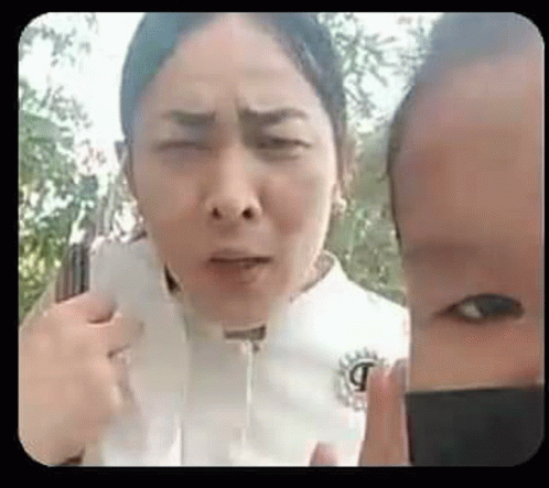 a woman and a child are standing next to each other and making funny faces .