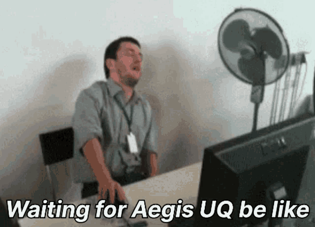 a man sitting in front of a computer with the words waiting for aegis uq be like on the screen