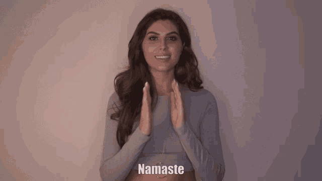 a woman with her hands folded and the word namaste written below her