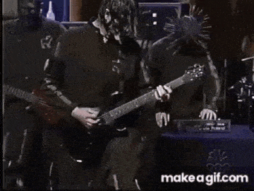 a man is playing a guitar on stage in front of a microphone .