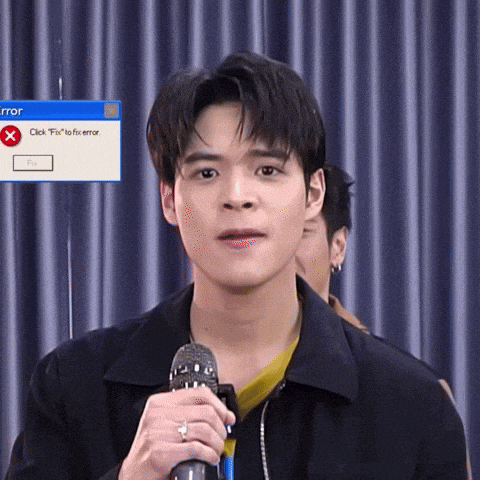 a man holding a microphone in front of a computer screen that says error