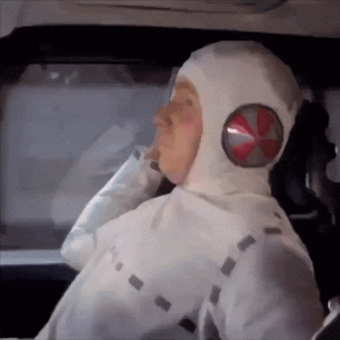 a man wearing a white hooded costume with a red umbrella symbol on his head