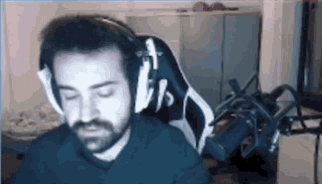 a man with a beard is sitting in a chair with headphones on .