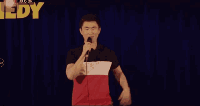 a man is giving a comedy show in front of a crowd