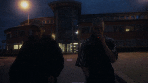 two men standing in front of a building that says ' a ' on the front