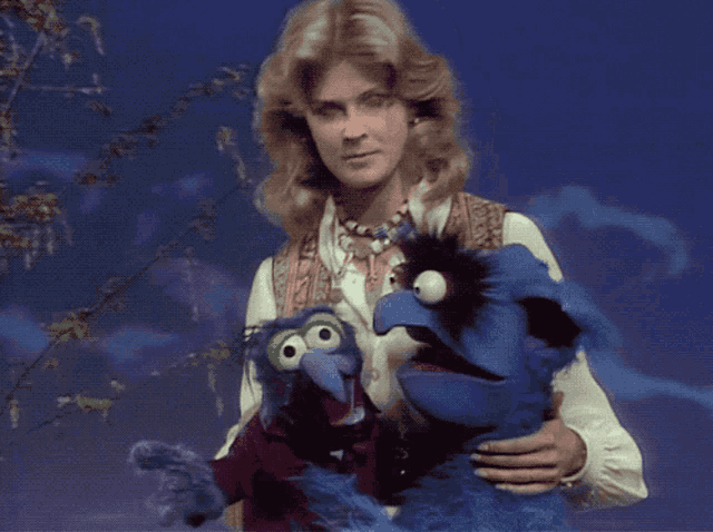 a woman holds two stuffed animals in her arms one of which is a cat