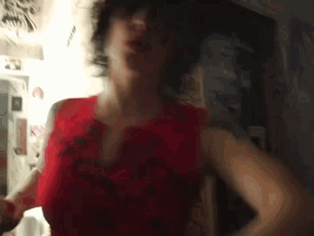 a woman in a red dress is standing in a room .