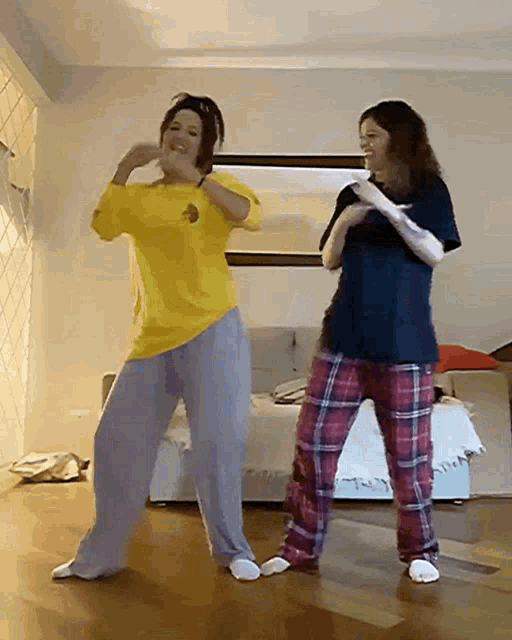 two women are dancing together in a living room