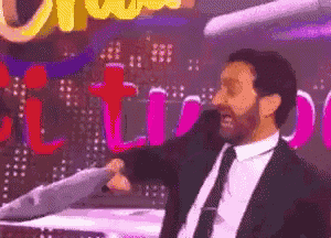 a man in a suit and tie is holding a fish in front of a sign that says ' ultimate '