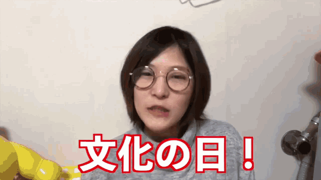 a woman wearing glasses is making a funny face in front of a sign that says ' i love you ! '