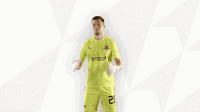 a soccer player wearing a yellow etoro jersey