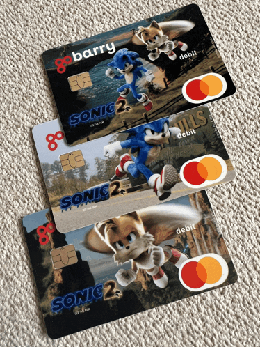 three sonic the hedgehog credit cards are on a carpet