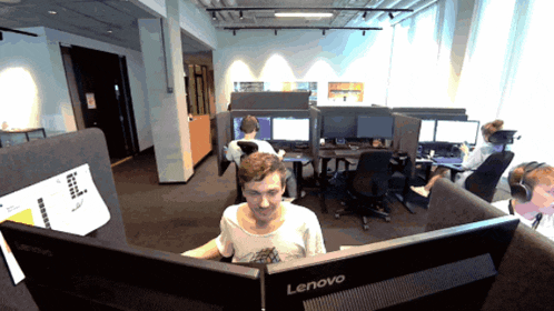 a man sits in front of a lenovo computer monitor