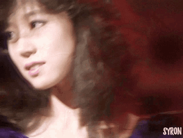 a close up of a woman 's face with syron written on the bottom right