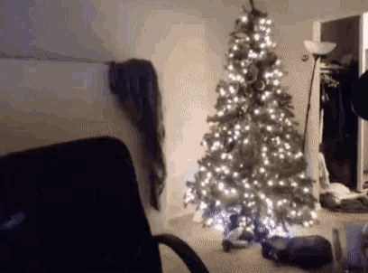 a christmas tree in a room with a chair in front of it