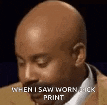 a bald man in a suit and tie is making a funny face .
