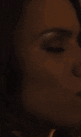 a close up of a woman 's face in a dark room .