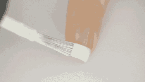 a close up of a person applying nail polish with a brush .