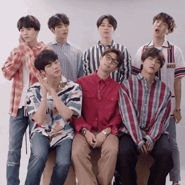 a group of young men are posing for a picture and one of them has a gucci shirt on