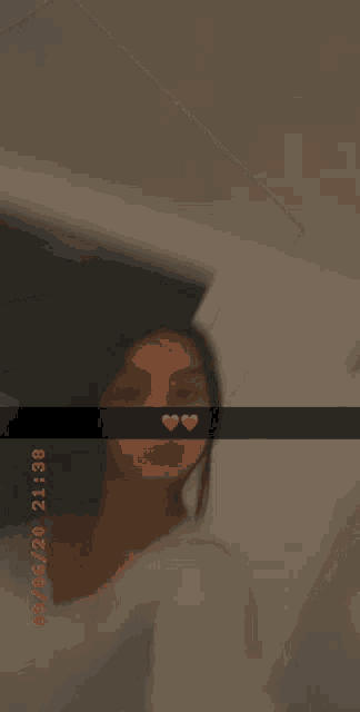 a woman is taking a selfie in a room with a heart on her face .