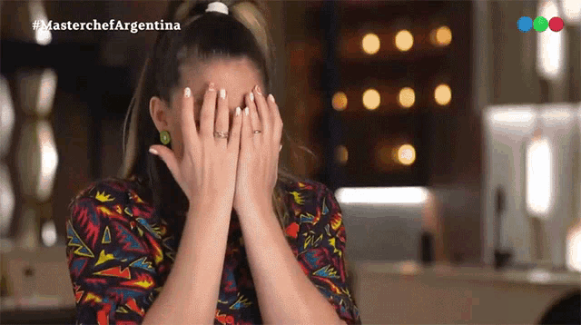a woman is covering her face with her hands and the words masterchef argentina are on the bottom
