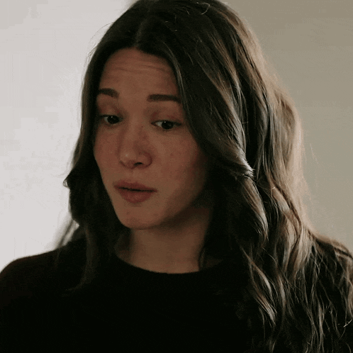 a close up of a woman 's face with long brown hair