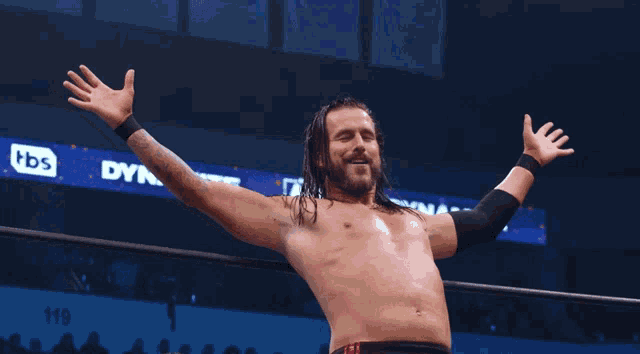 a man in a wrestling ring with his arms outstretched in front of a tbs sign