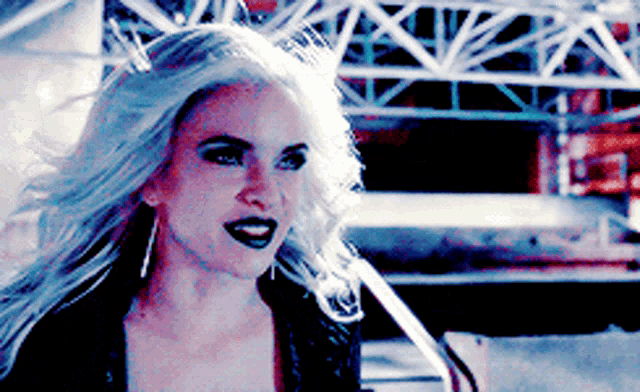 a woman with long white hair and black lipstick is smiling