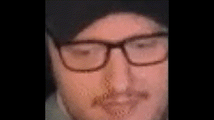 a close up of a man 's face with glasses and a hat .