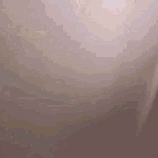 a blurred image of a person 's hand with a shadow on the wall