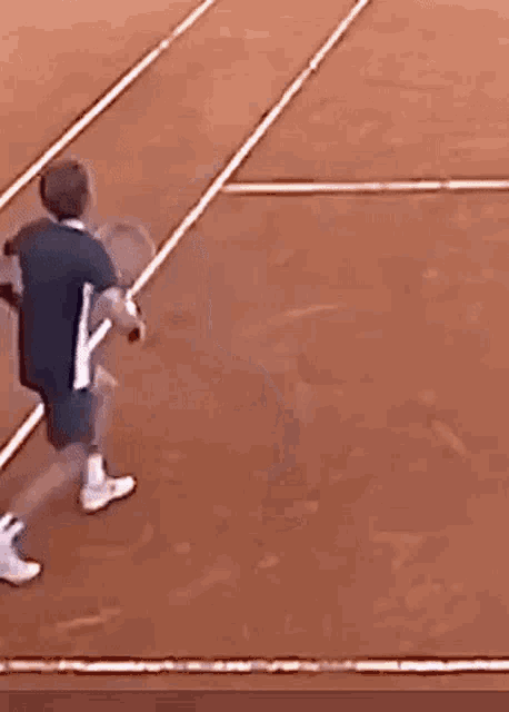 a man is holding a tennis racquet on a tennis court
