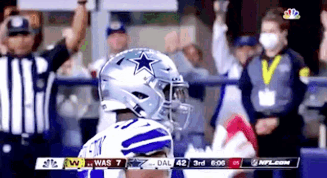 a football player wearing a helmet with a star on it stands in front of a crowd during a game .
